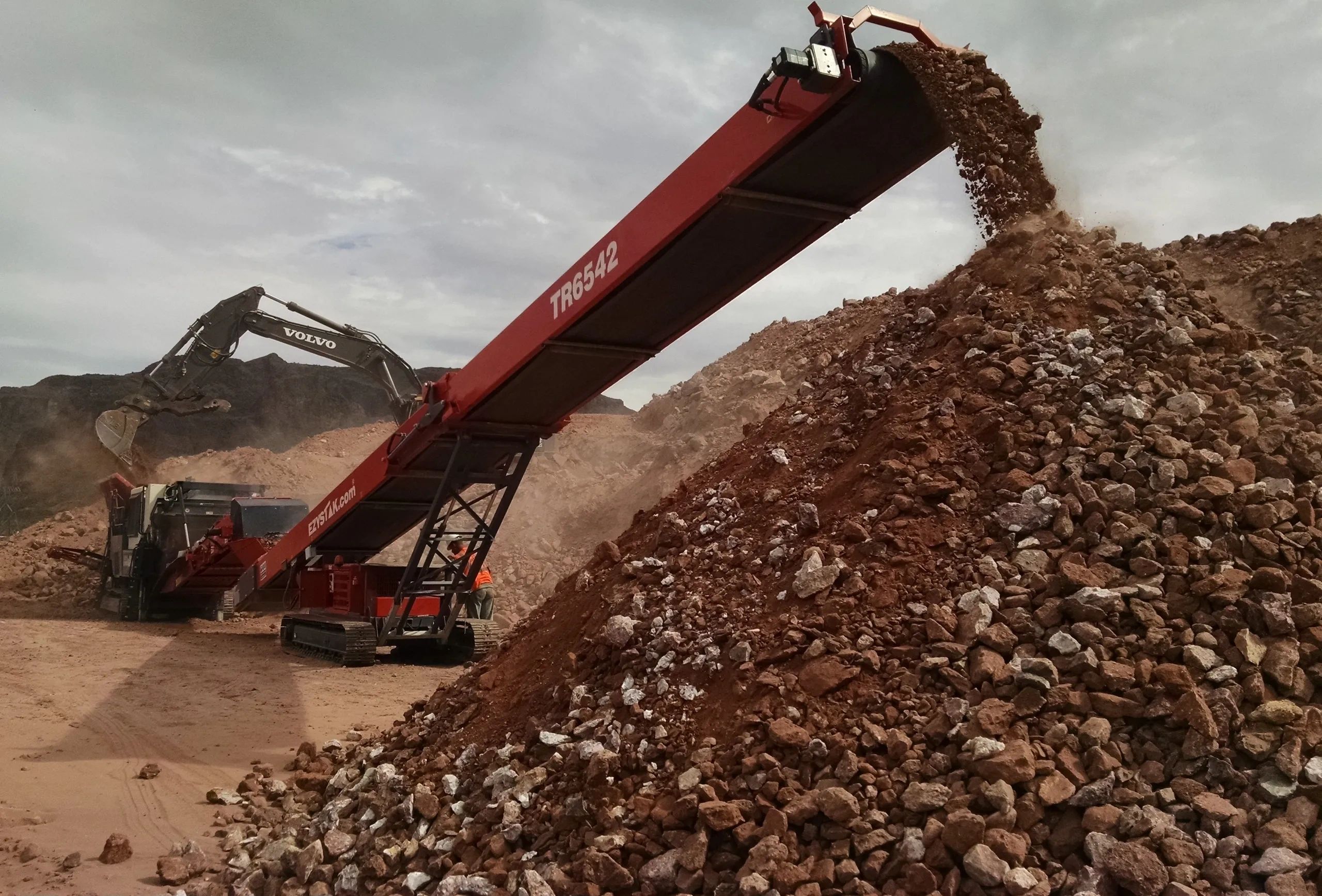 Excavator and crushing equipment operating at a Southwest desert site